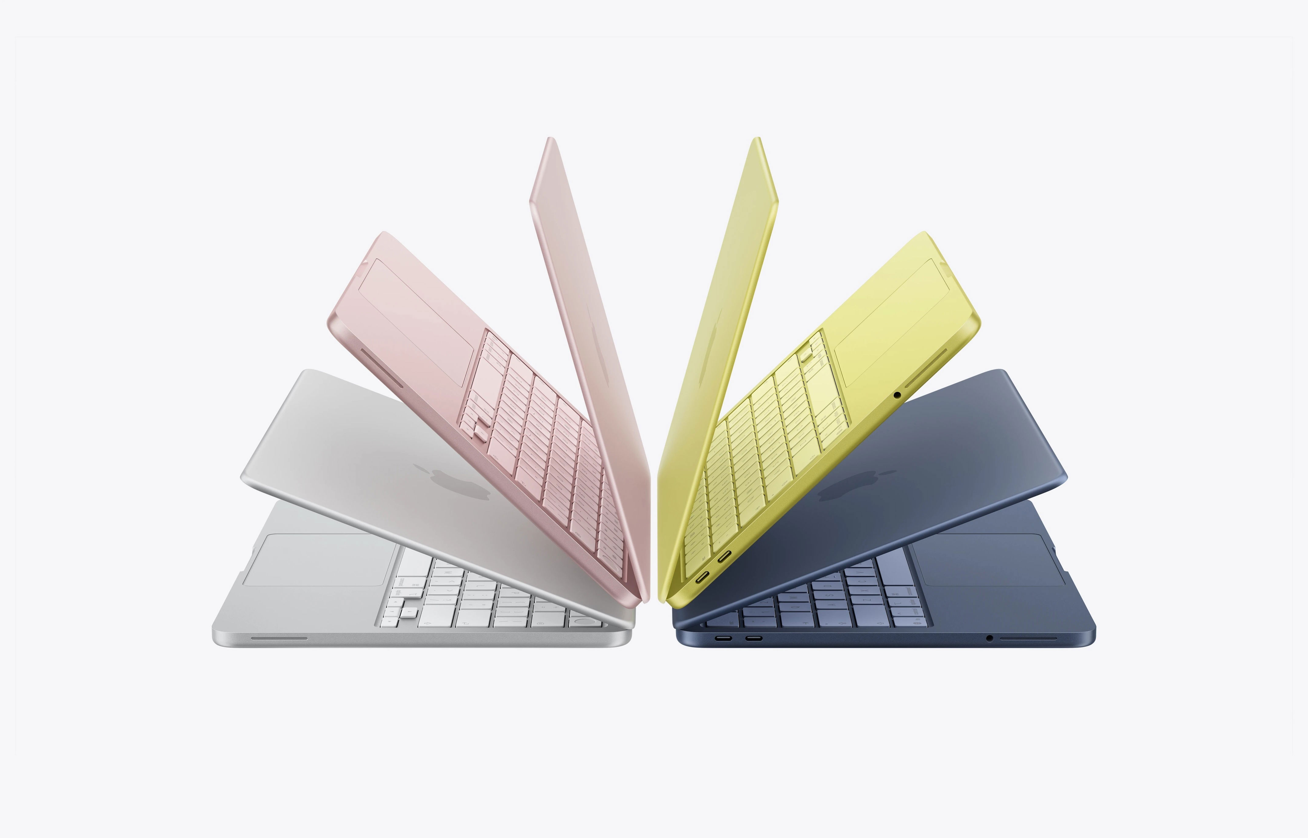 Apple MacBook Neo in Blush Pink and Citrus Yellow colors on a desk