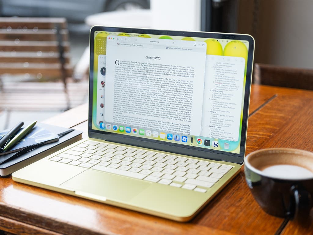 Apple MacBook Neo on a desk with coffee cup